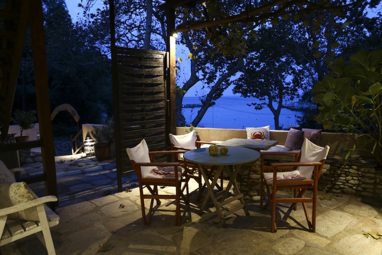 Ulrich studio's spacious terrace with the view of the Aegean Sea at Damouhari harbor in a moment of dusk